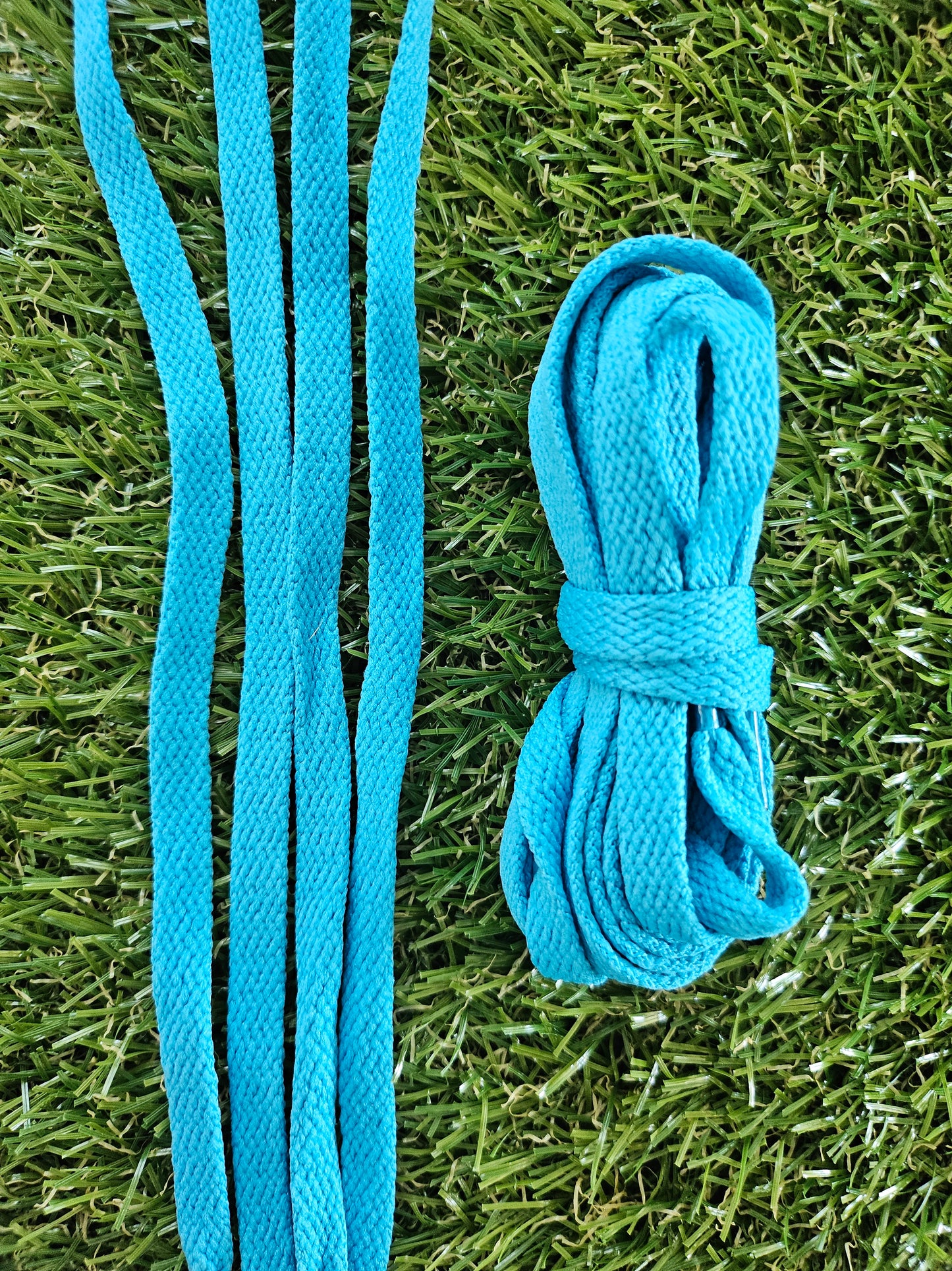 Blue turquoise shoelaces on a grass background