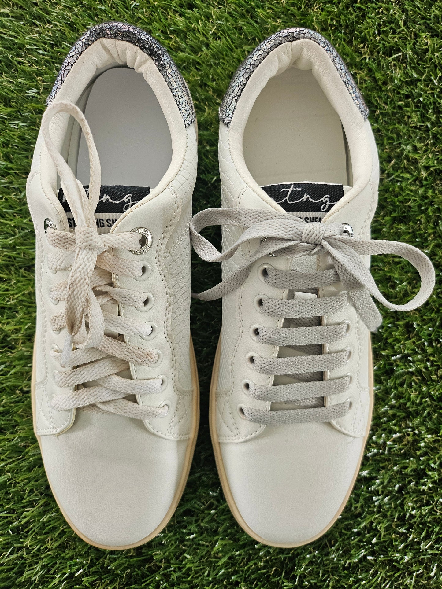 Pair of white sneakers on grass
