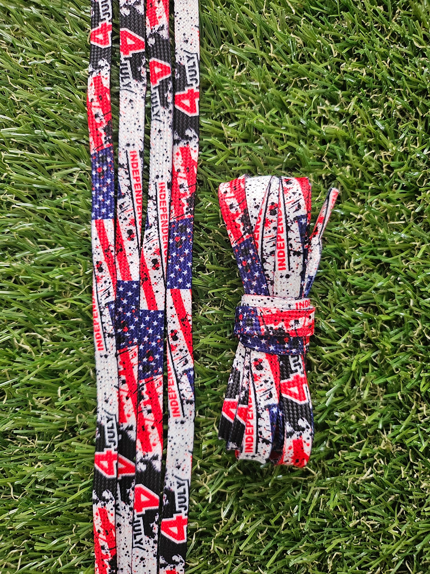 Pair of American flag-themed shoelaces on grass