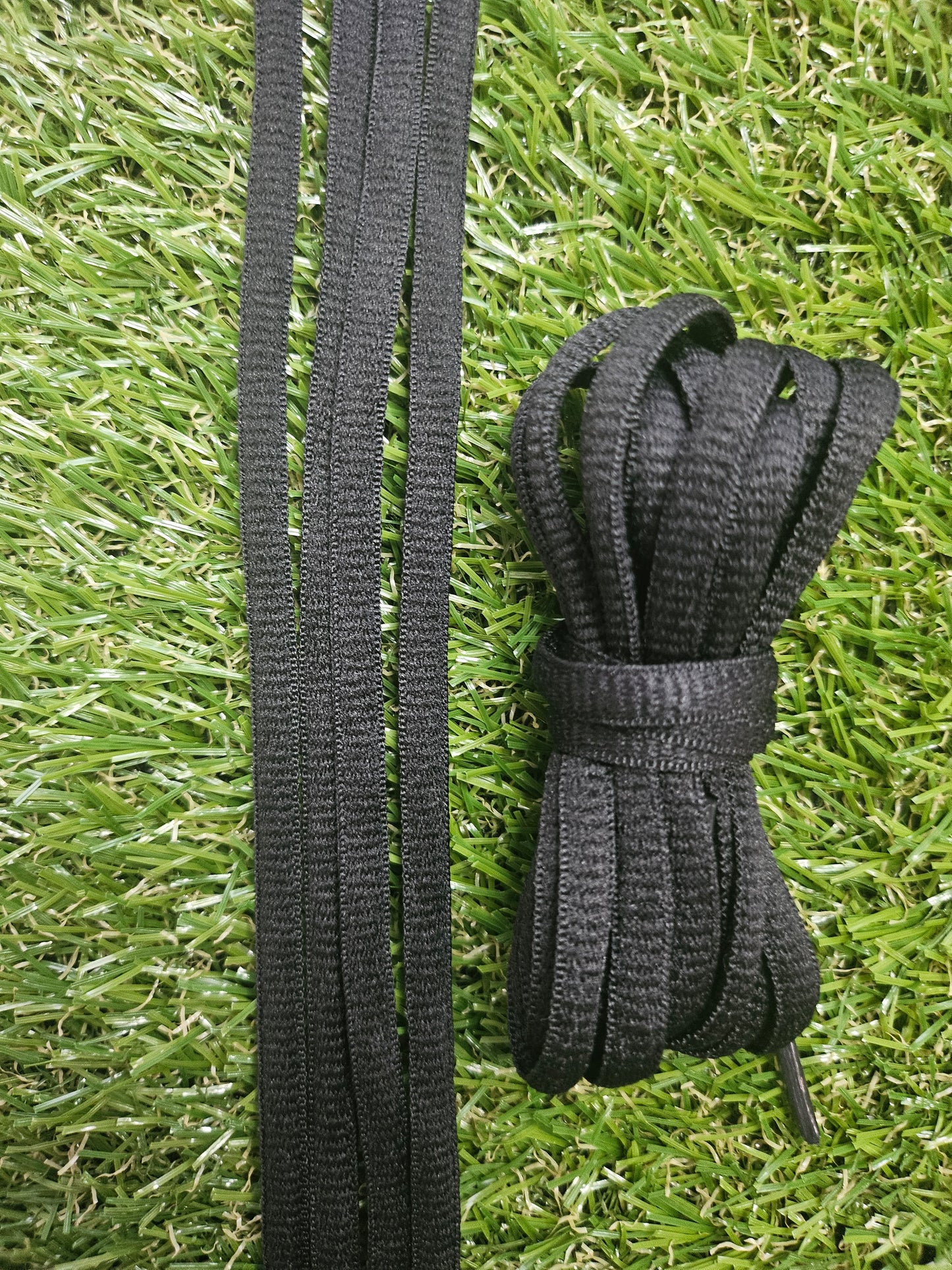 Black shoelaces on a grass background