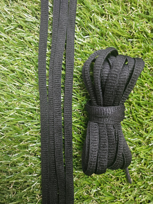 Black shoelaces on a grass background