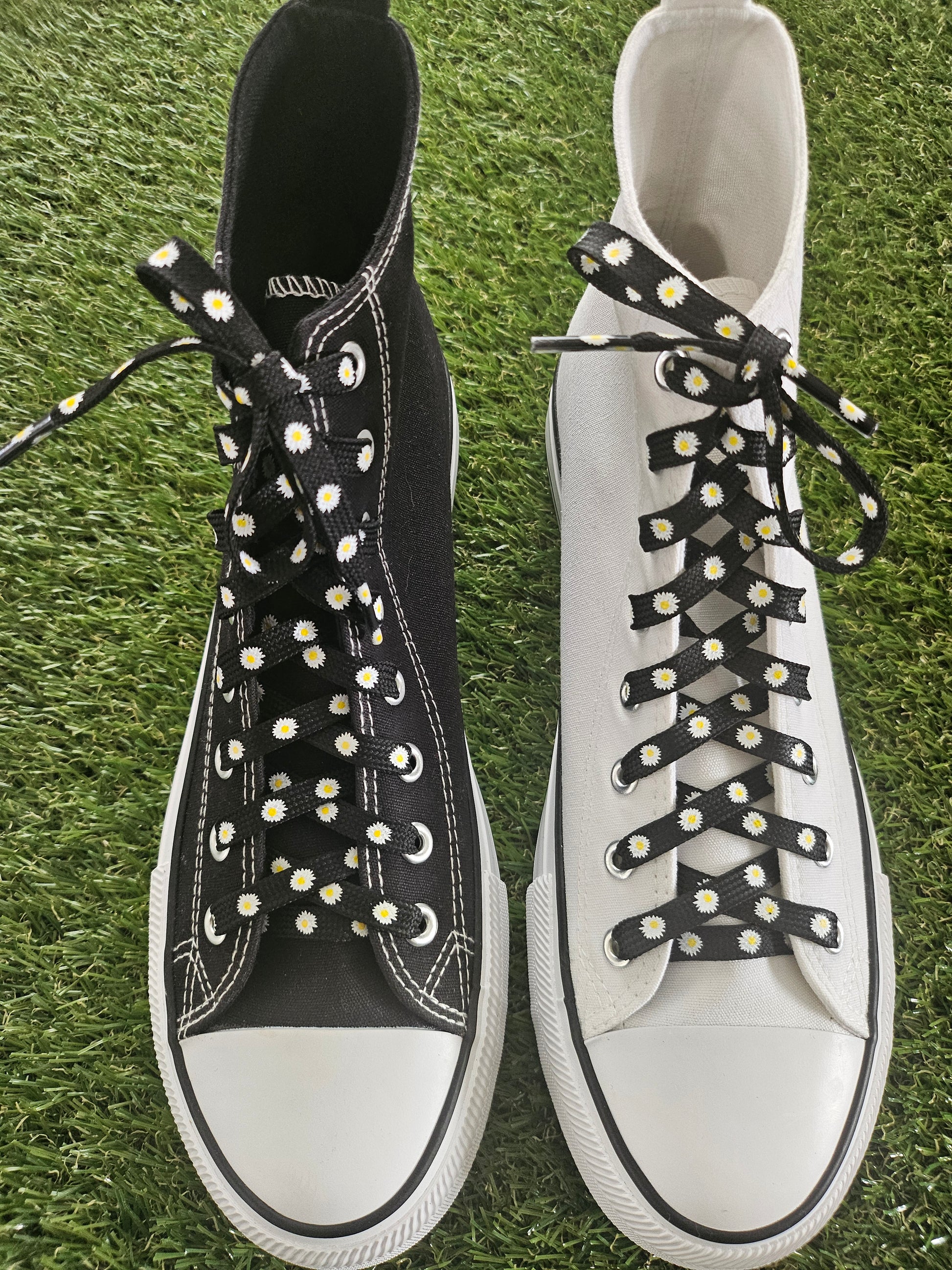 Black shoelaces with white daisy pattern styled on white trainers