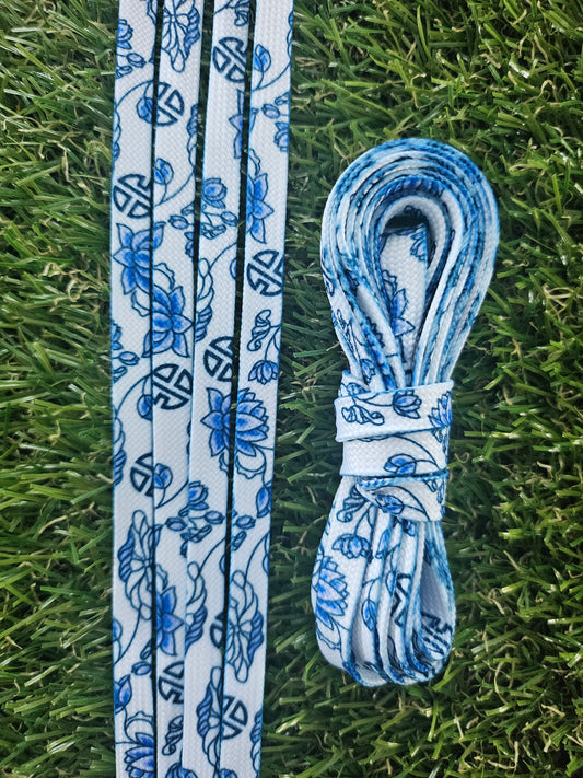 Blue and white floral-patterned shoelaces on grass