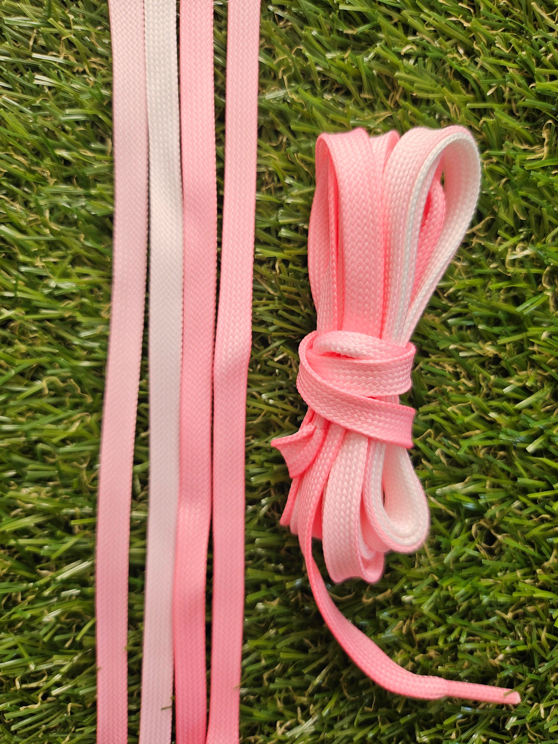 Pink shoelaces on a grass background