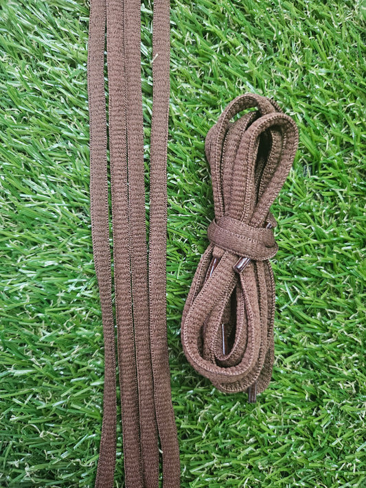 Classic Brown oval shoelaces on a grass background