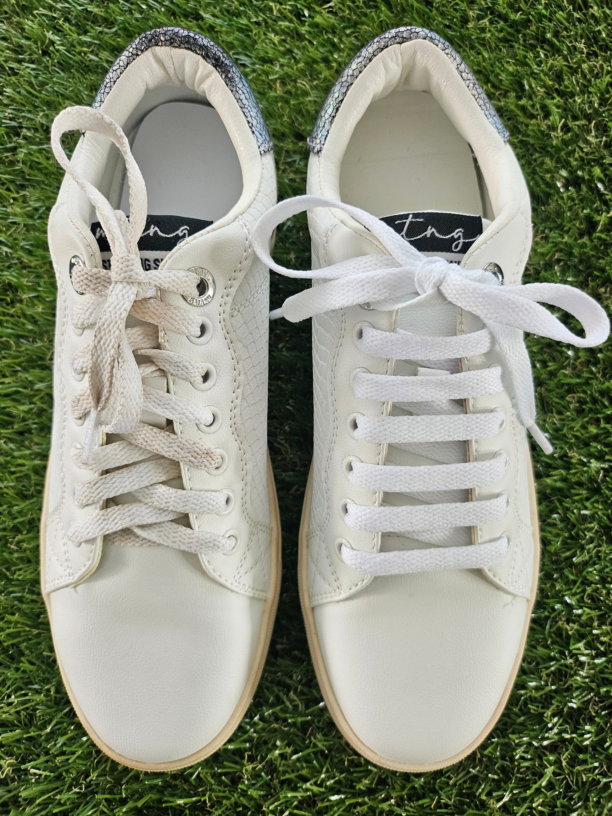 Pair of white sneakers on grass