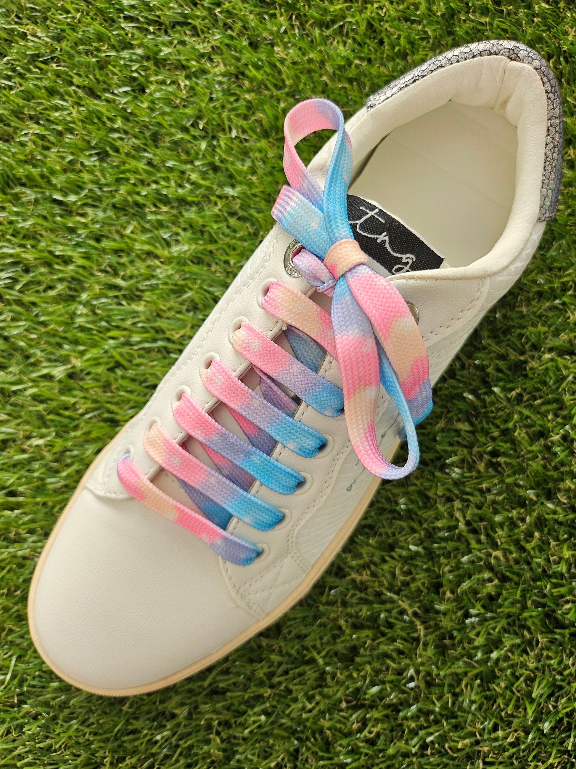 Cloud Candy Fade shoelaces on a grass background