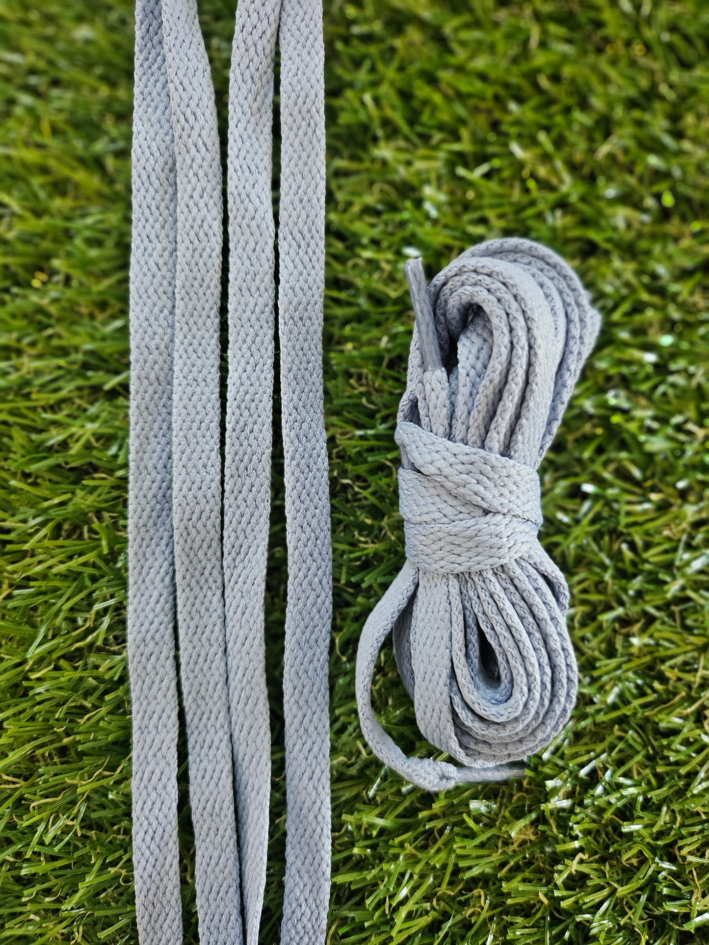 Grey shoelaces on green grass