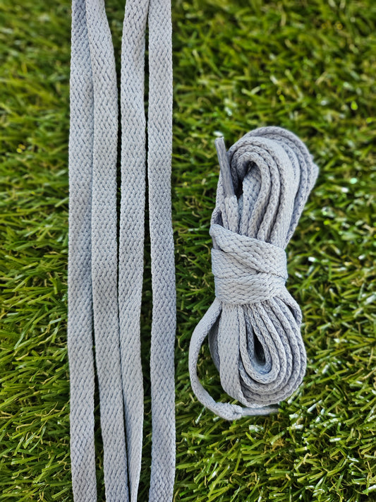Grey shoelaces on green grass