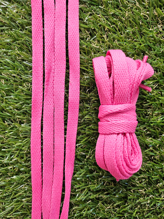 Pink shoelaces on a grass background