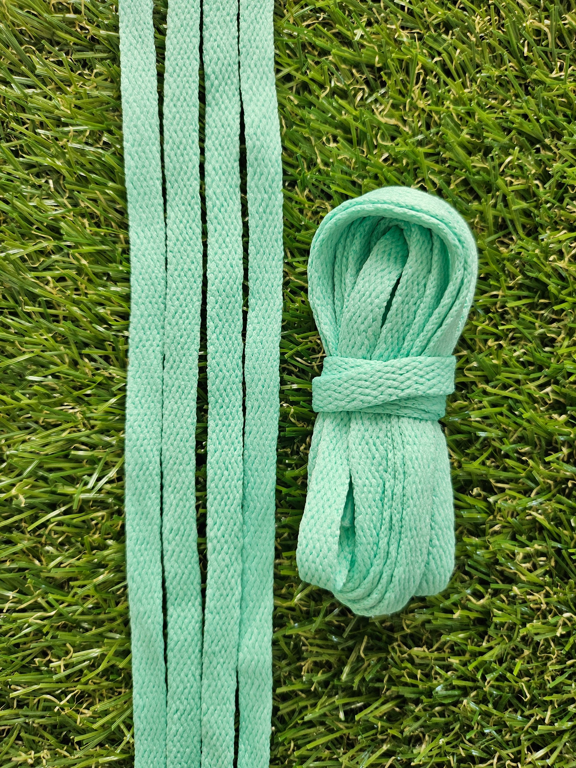 Light green coloured shoelaces on grass