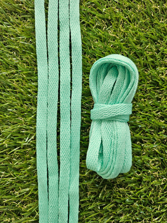Light green coloured shoelaces on grass