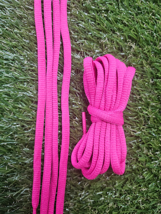 Pink shoelaces on a grass background