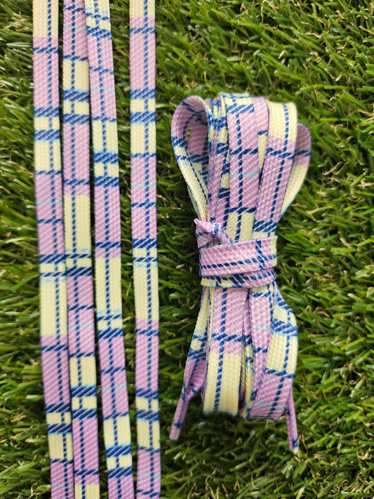 Yellow and purple shoelaces in lemon and lilac colours laid on grass