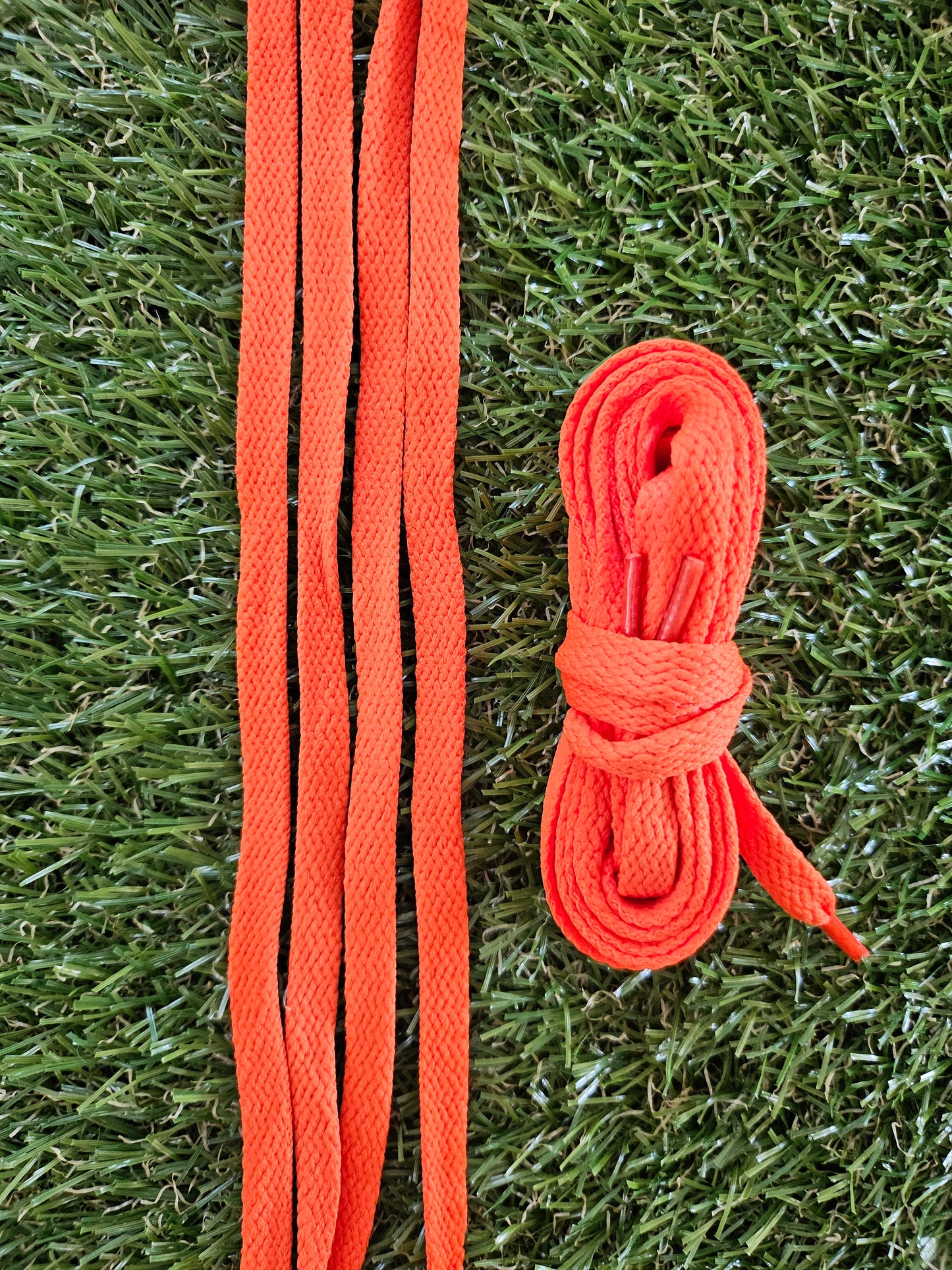 Bright orange shoelaces on orange grass