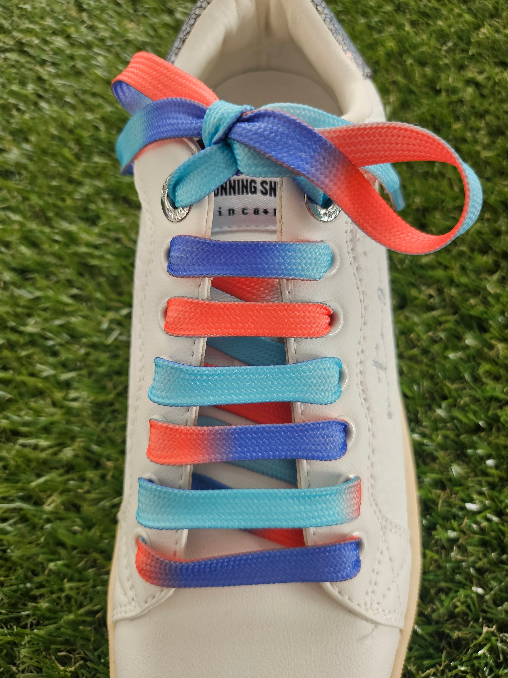 ocean sunset coloured shoelaces in a white trainer on grass