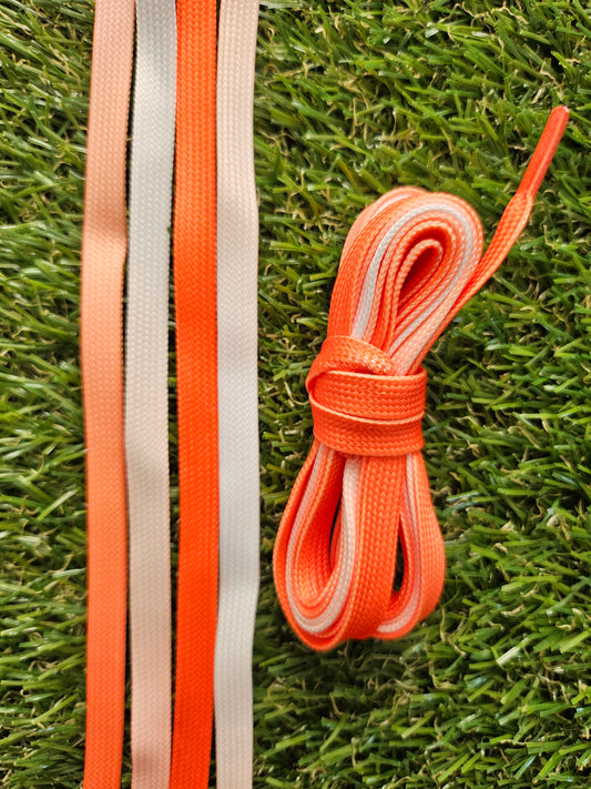 Orange fade shoelaces on green grass