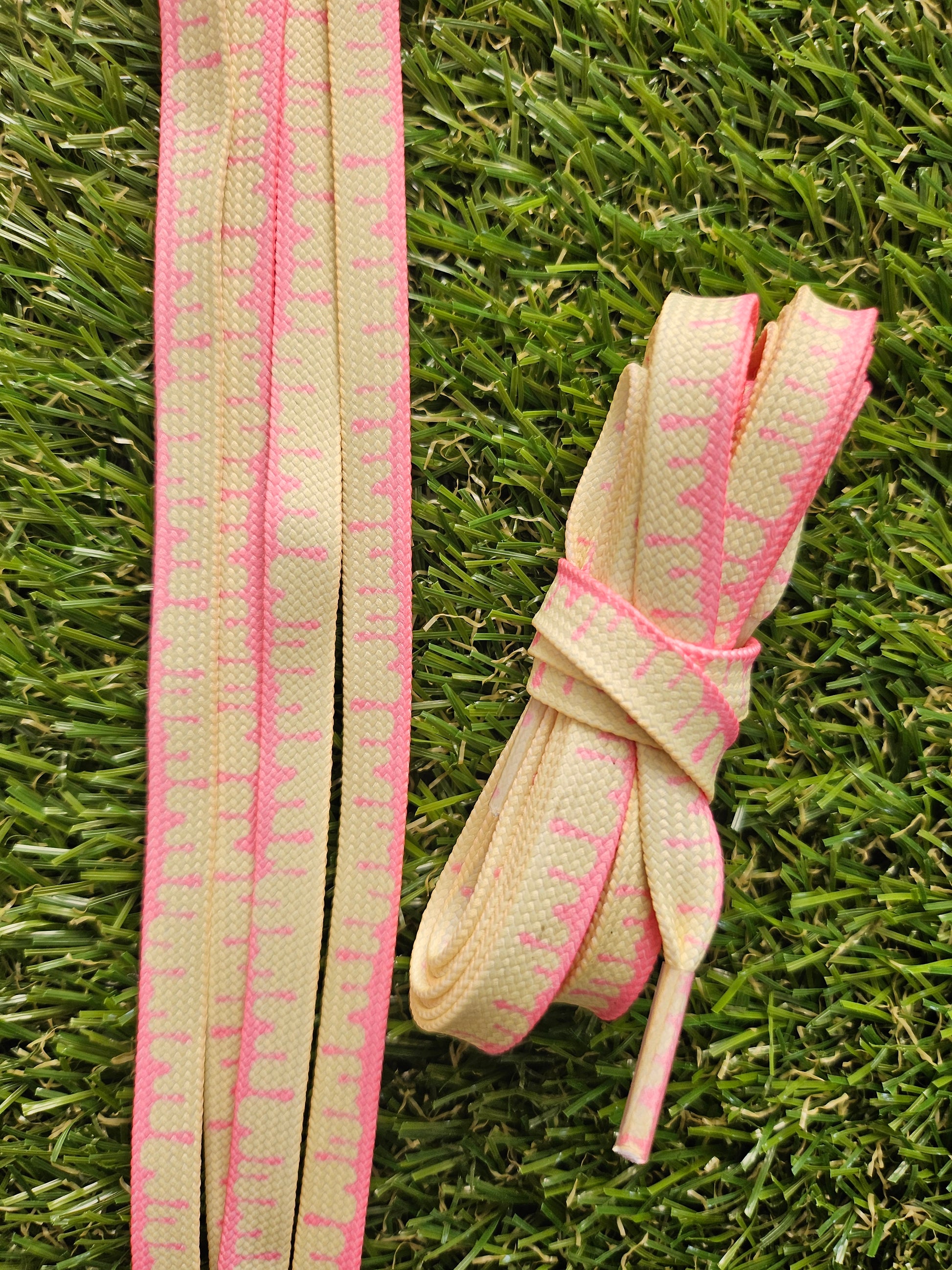 Paint Drip ShoeLaces - Lemon & Pink - lying on top of grass