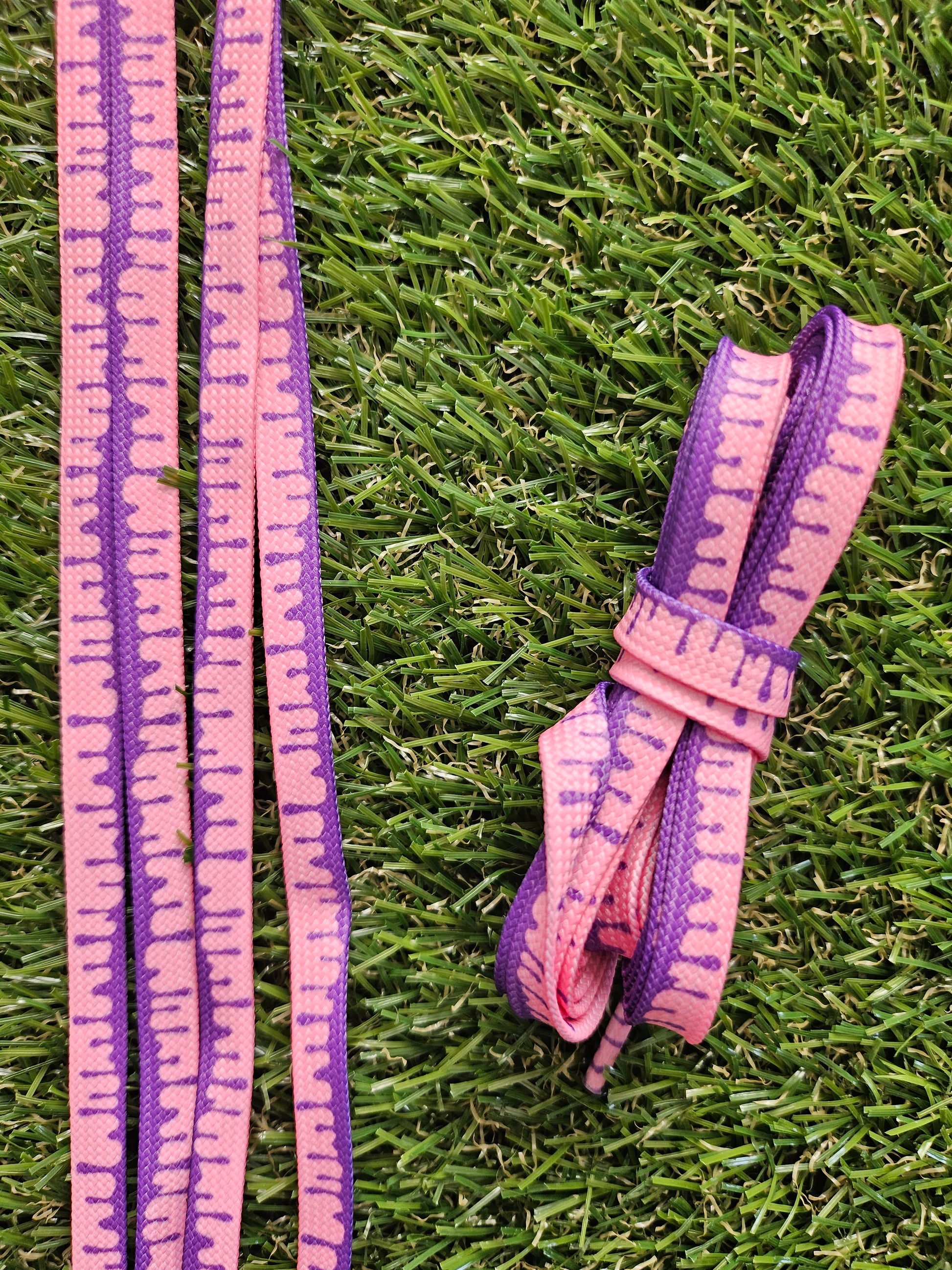 Pink and purple shoelaces on grass