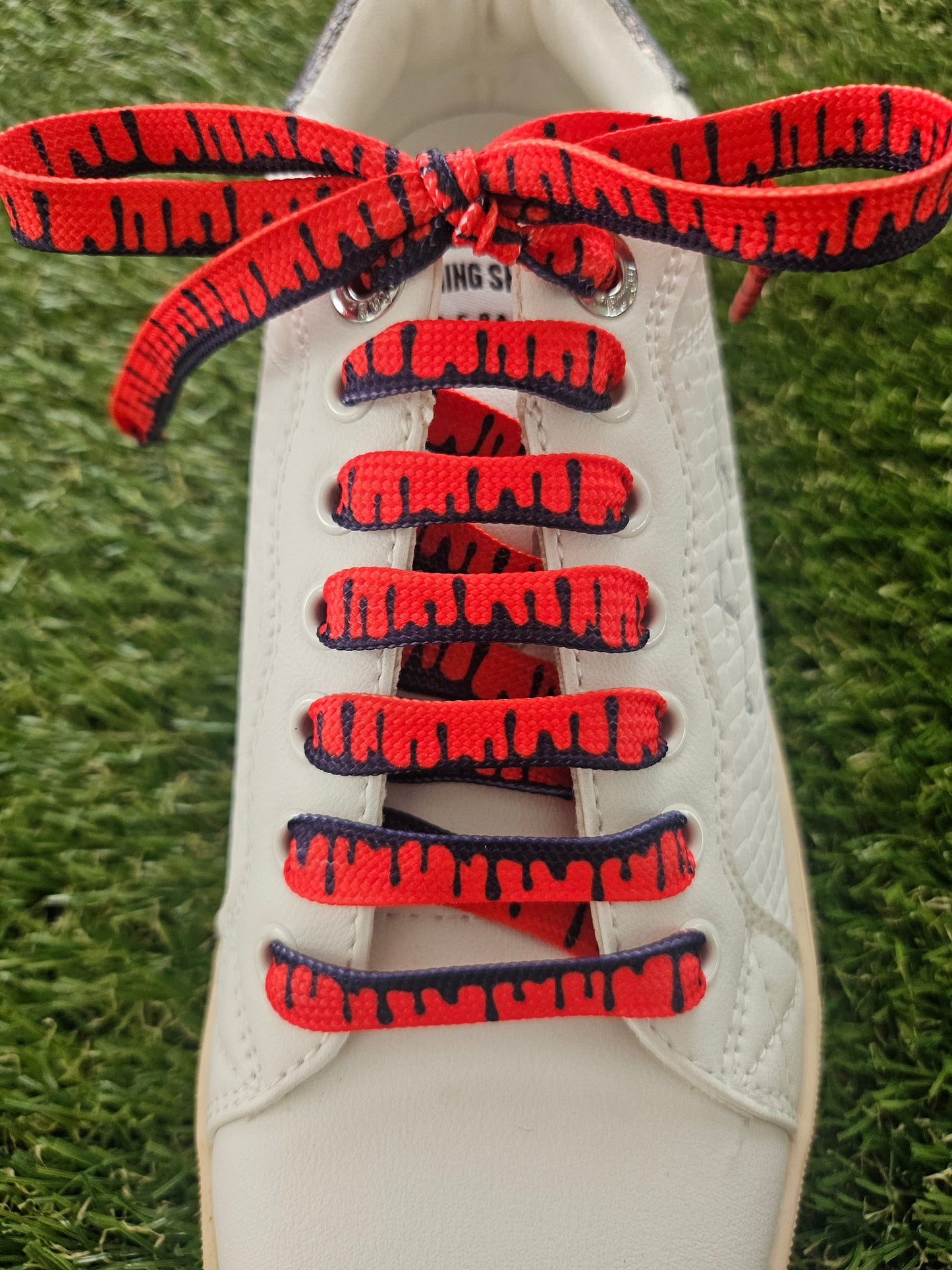 Red designer shoelaces with black drip pattern