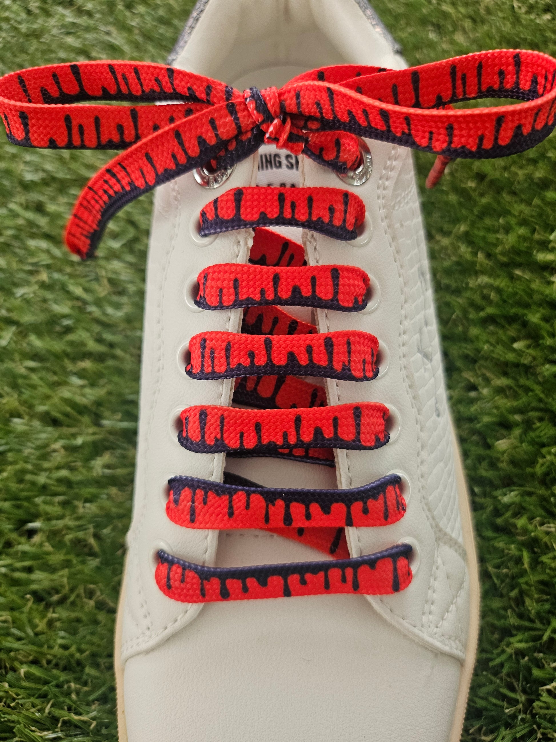 Red designer shoelaces with black drip pattern