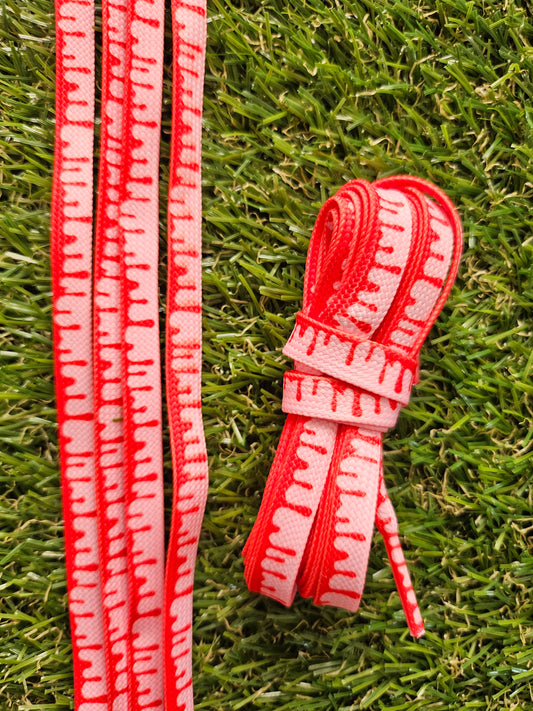 Red and pink shoelaces on grass
