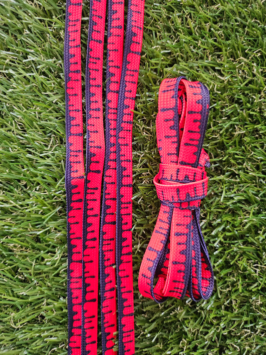 Red and Navy Blue Paint Drip shoelaces on green grass