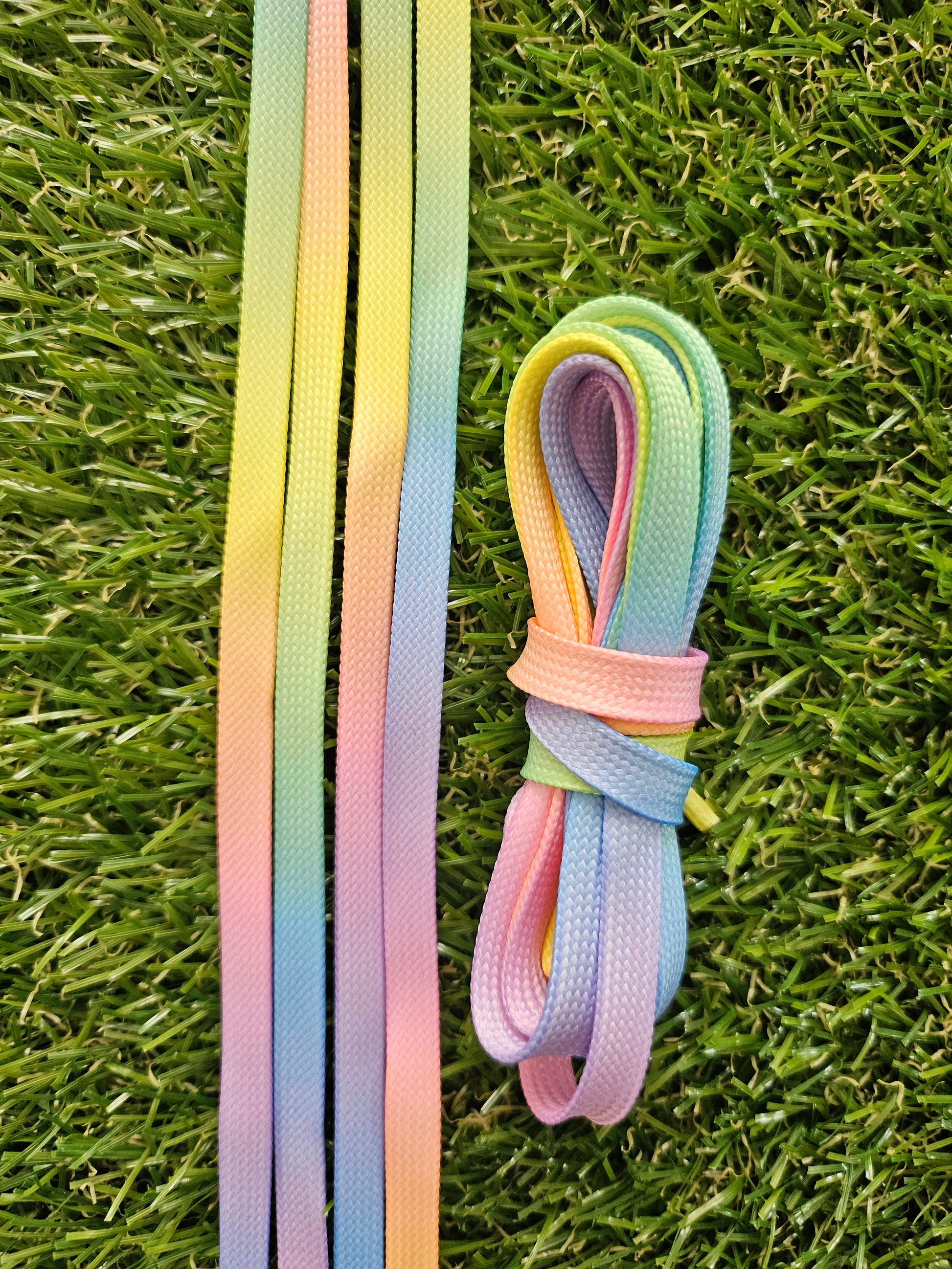 Pastel-colored shoelaces on a grass background