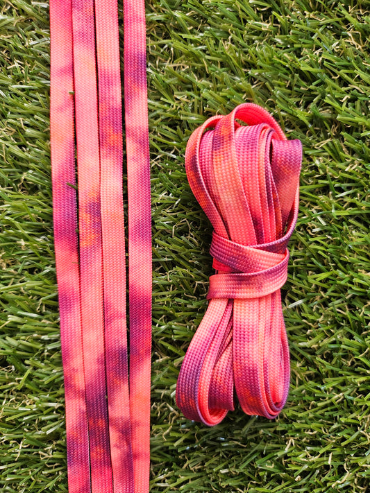 Pink and peach shoelaces on grass