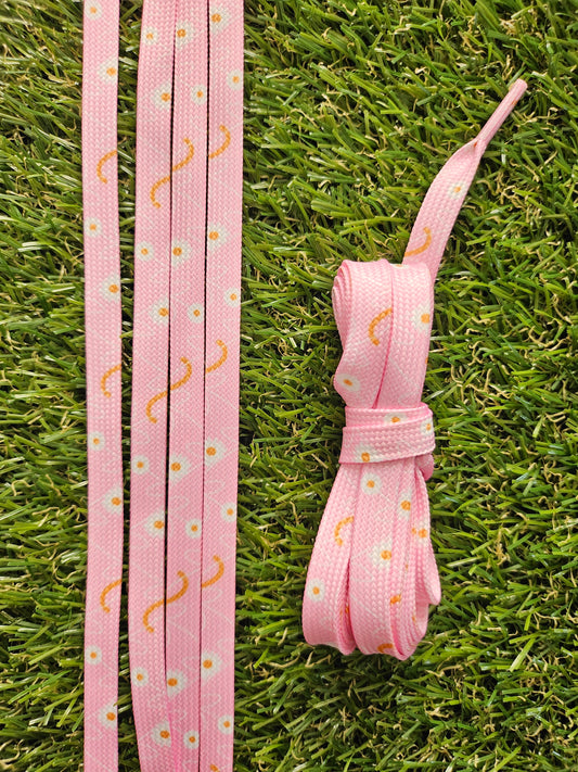 Pink shoelaces with a pattern on a grass background