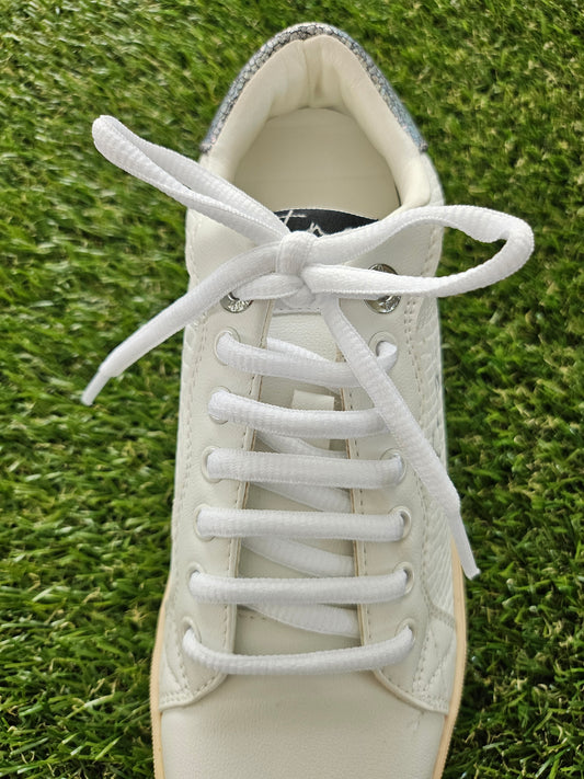 white shoelaces on white trainer on grass