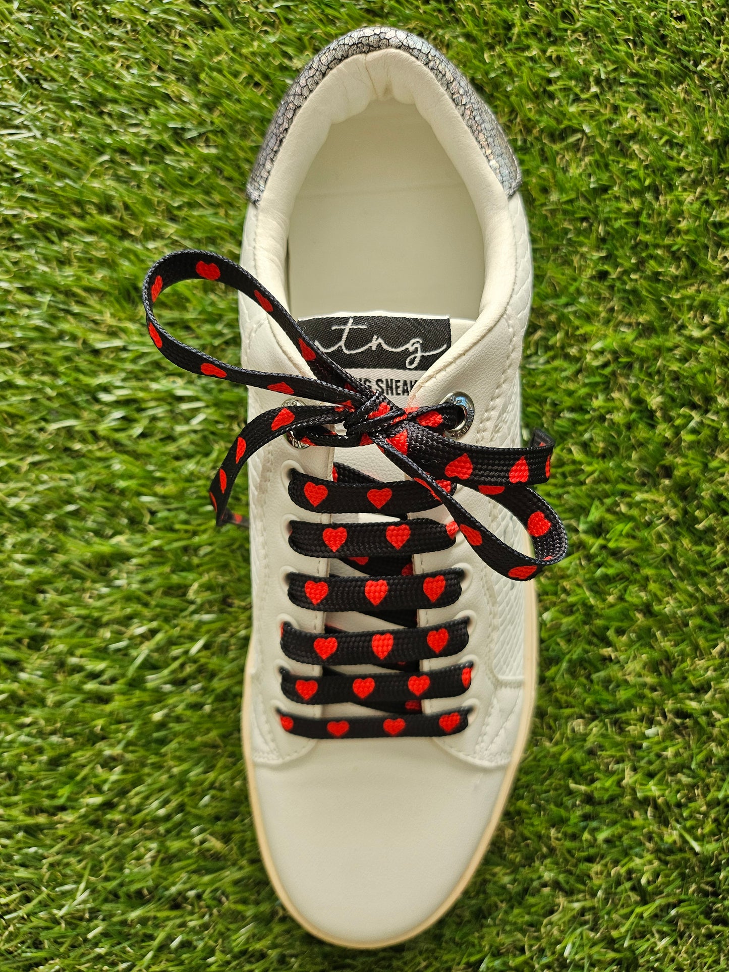 red hearts on black shoelaces on a white trainer