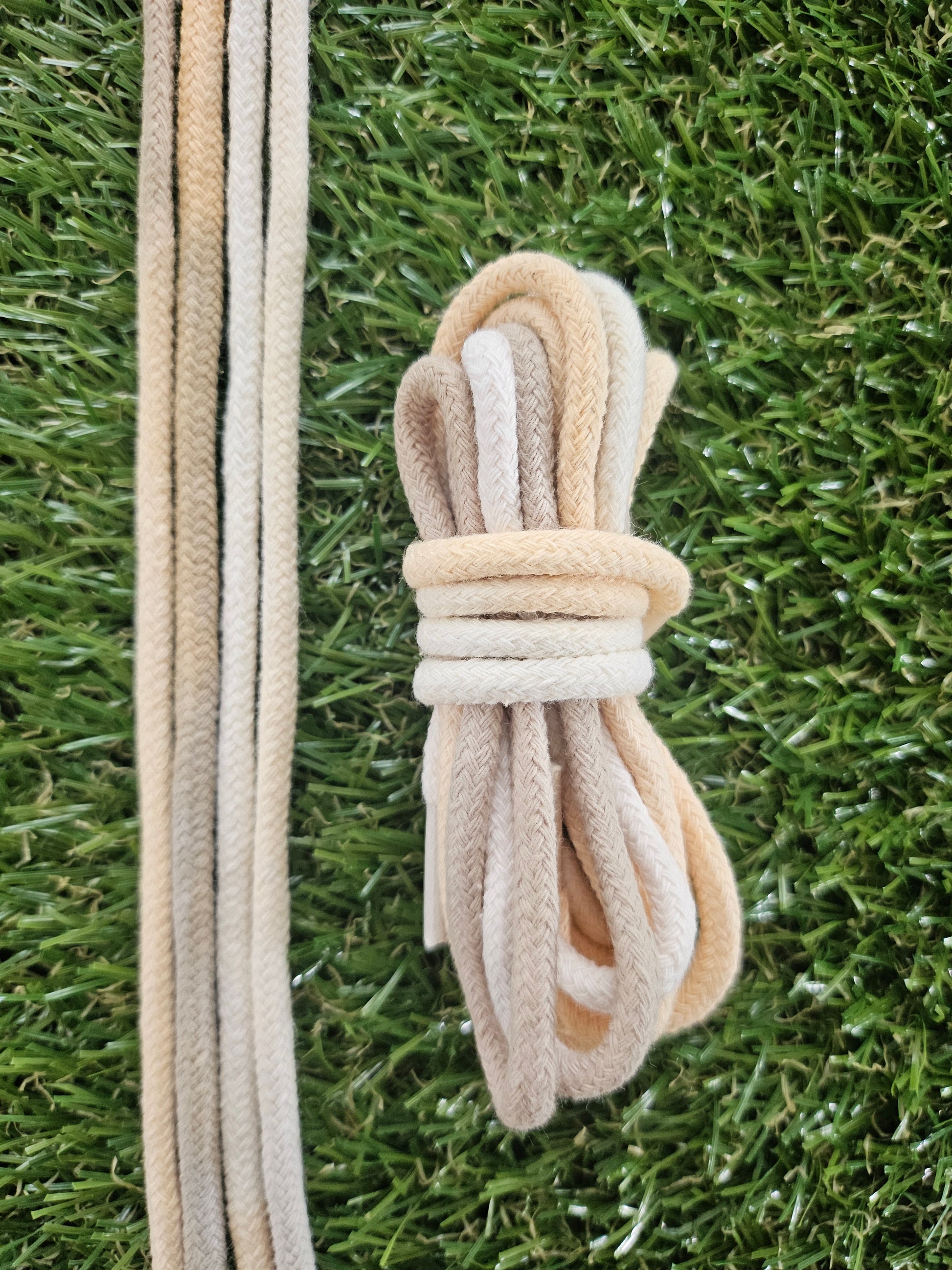 Set of beige shoelaces on a grass background