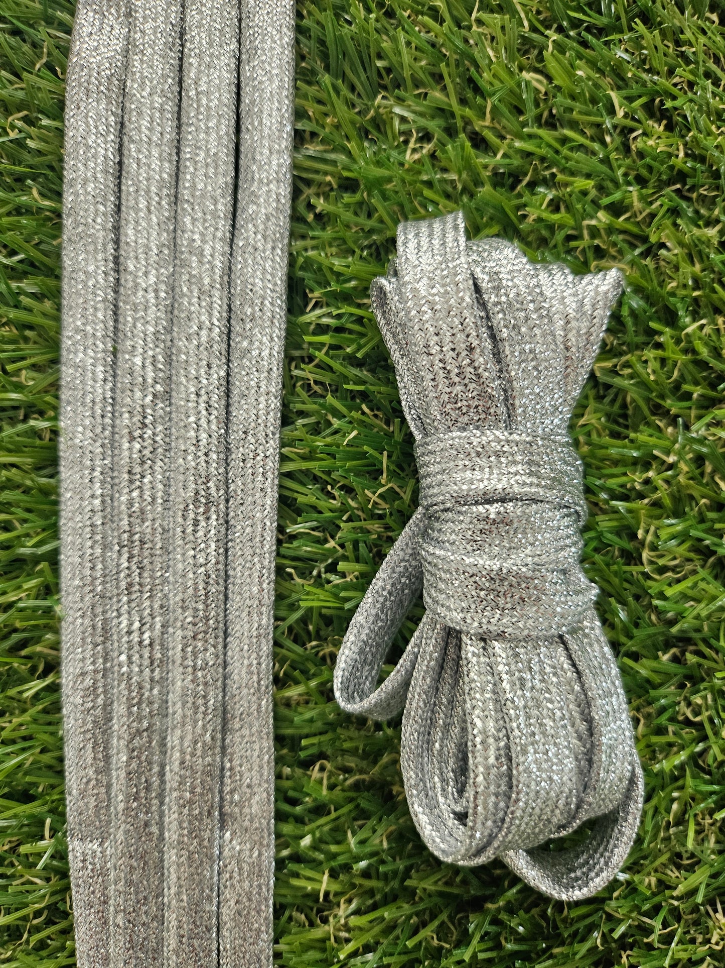 Silver shoelaces on grass