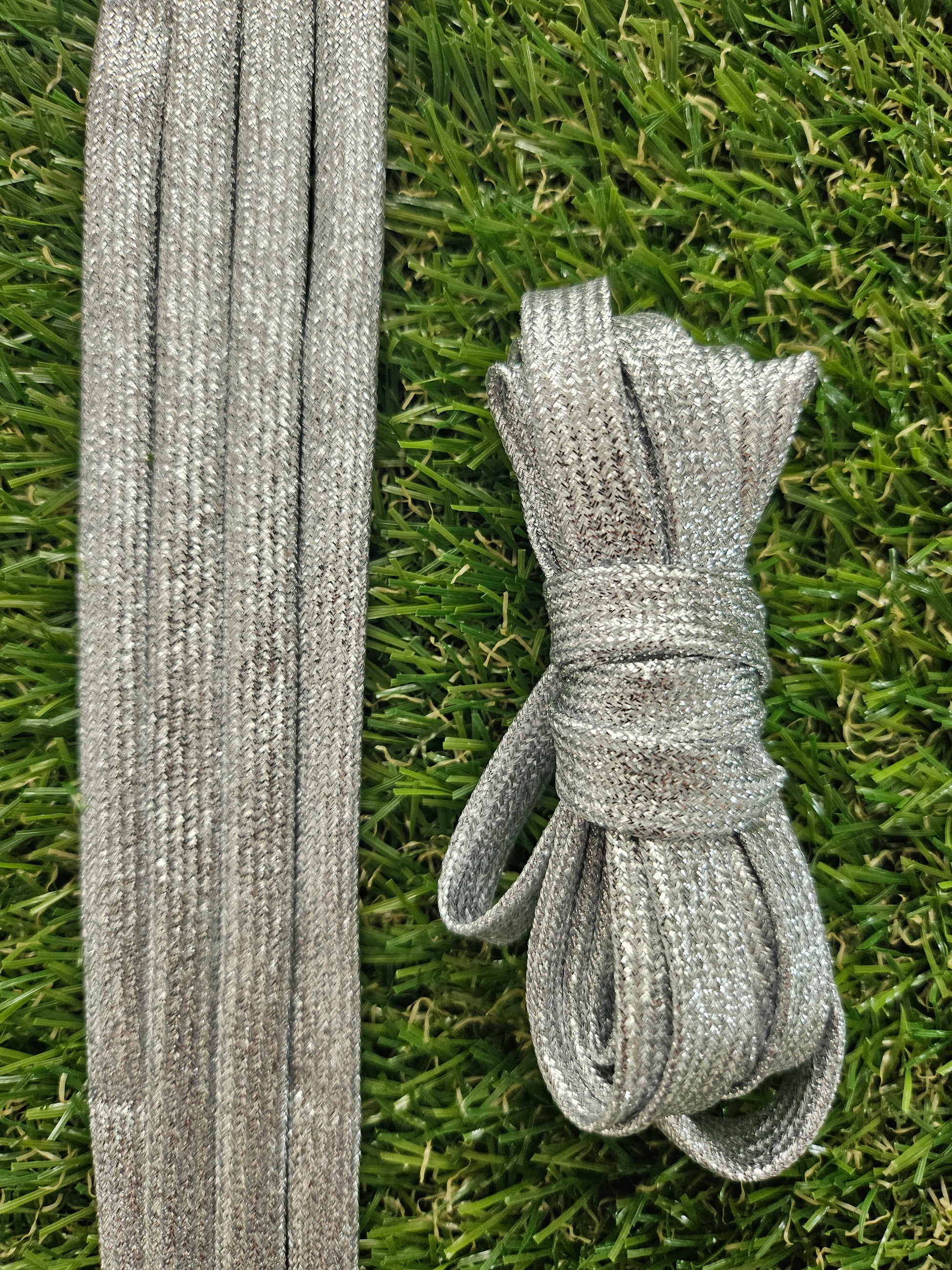 Silver shoelaces on grass