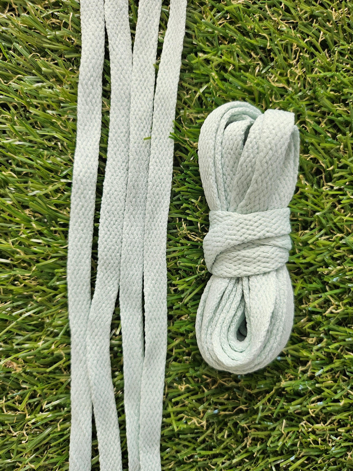 Soft sage green shoelaces on green grass