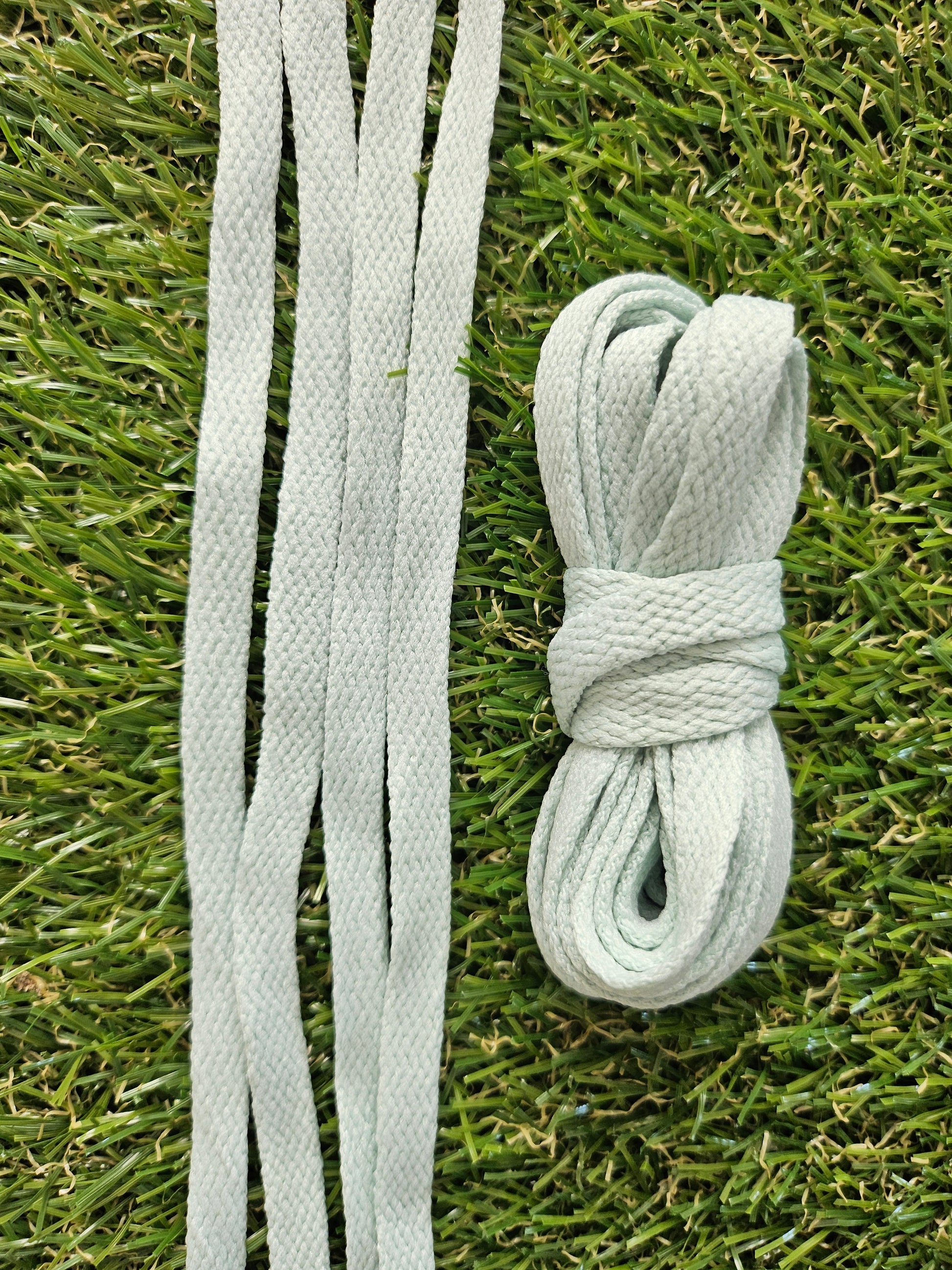 Soft sage green shoelaces on green grass