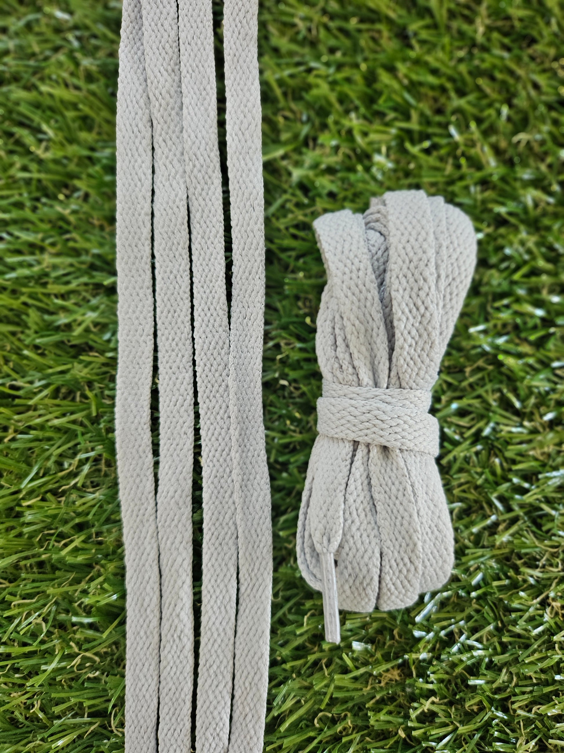 Gray shoelaces on a grass background