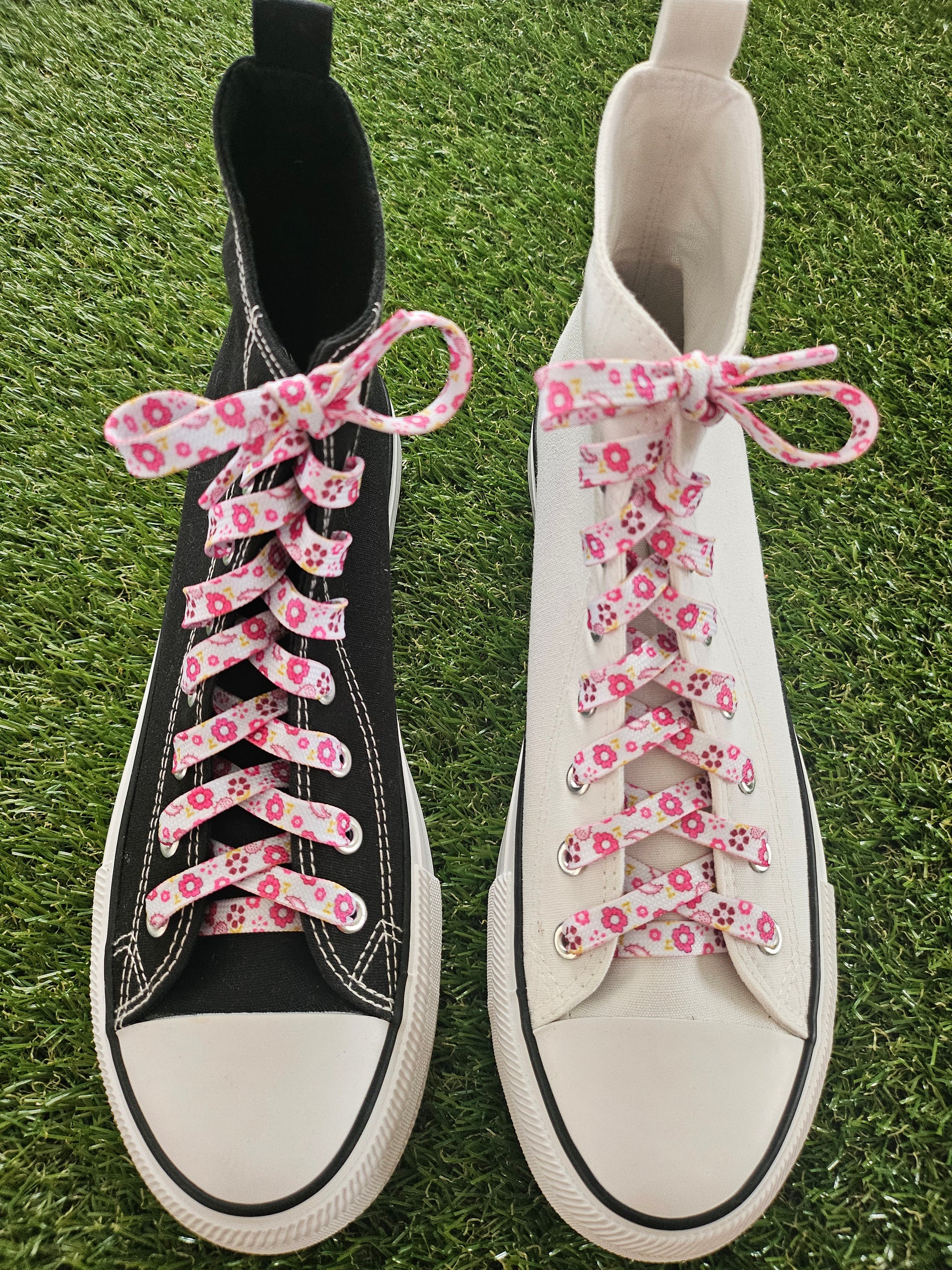 a black and a white converse baseball boot with pink floral laces