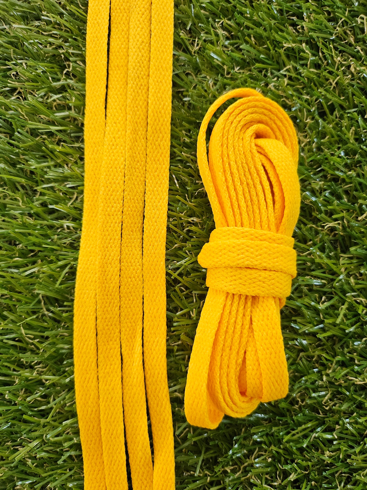 Yellow shoelaces on a grass background