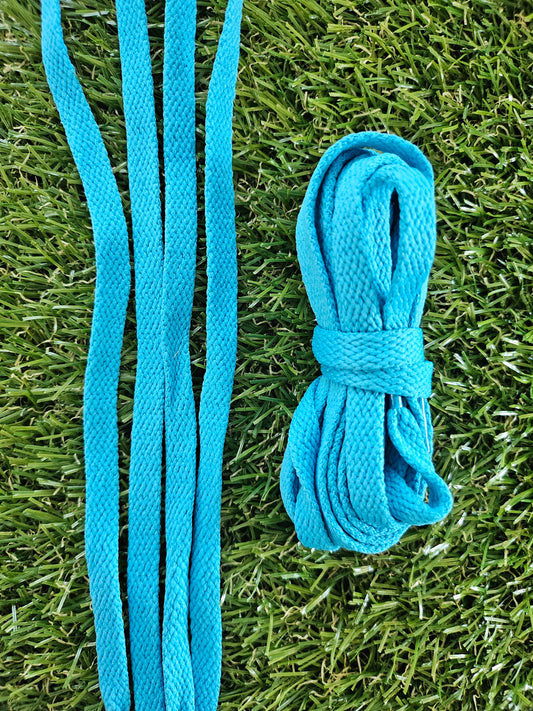 Blue turquoise shoelaces on a grass background