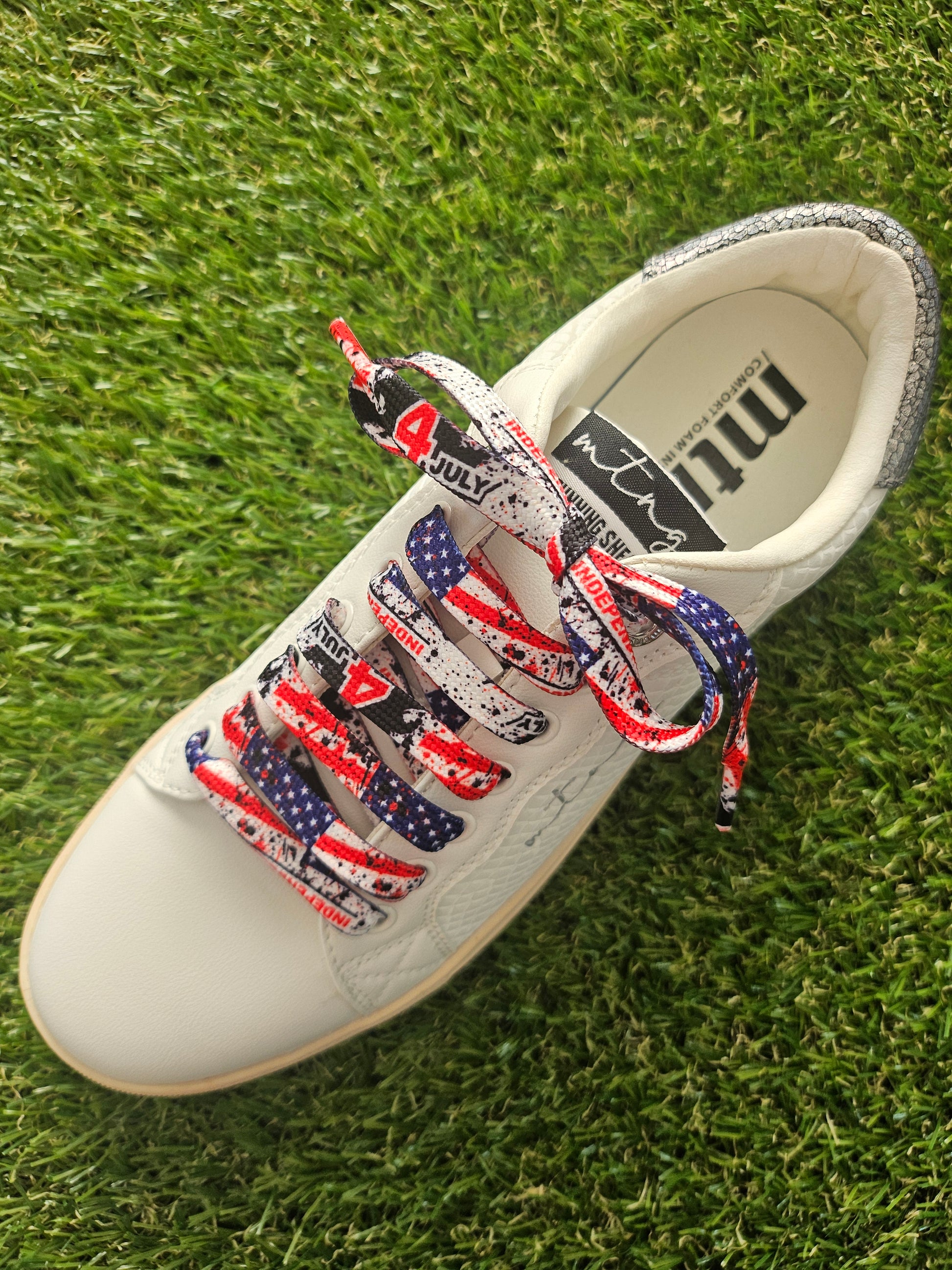 usa flag 4th July detailed shoelaces on a white trainer on green grass