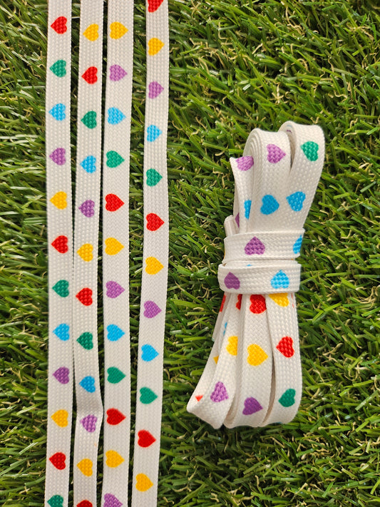 Colorful heart-patterned shoelaces on a grass background