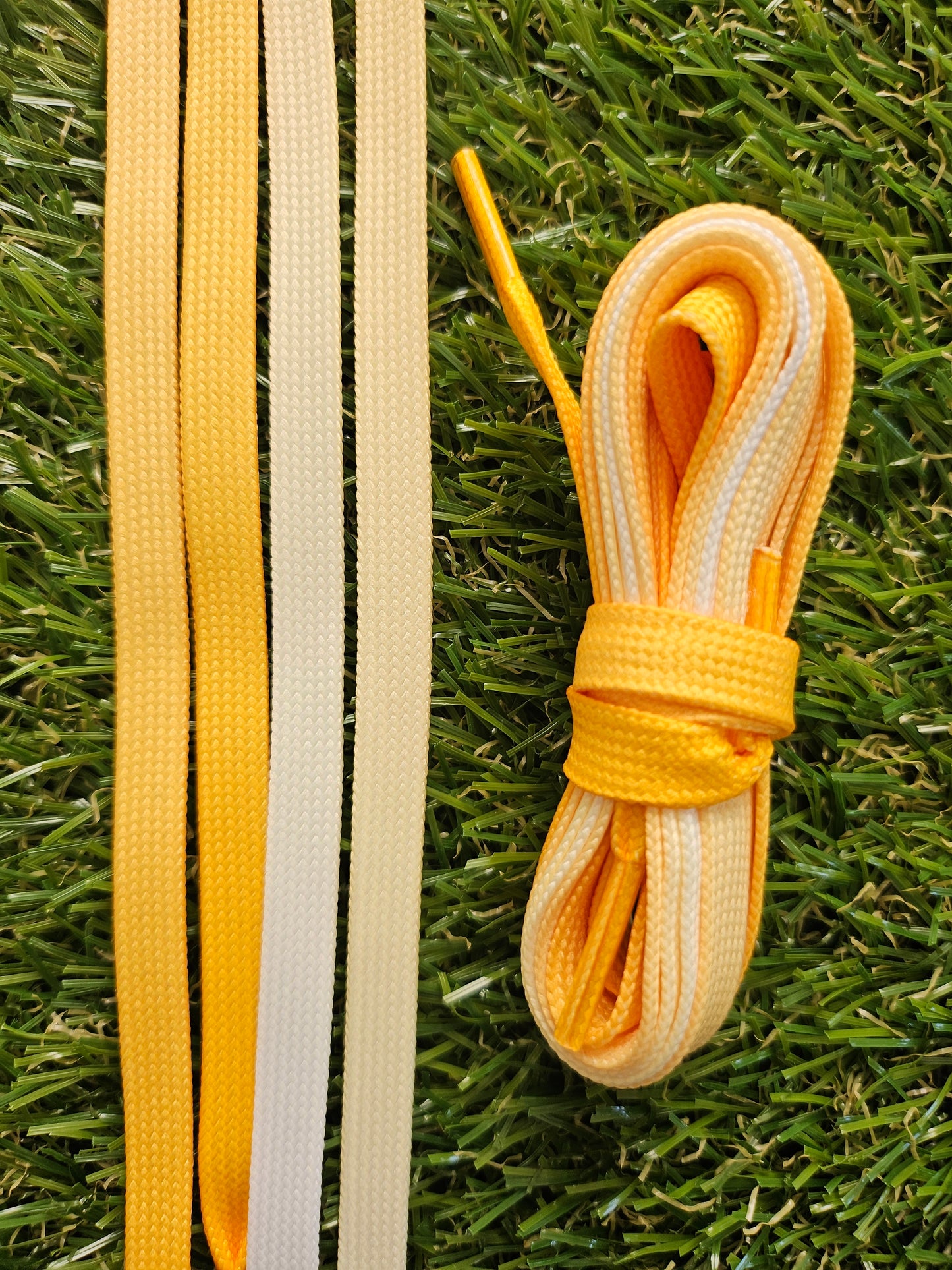 Yellow fade shoelaces on green grass
