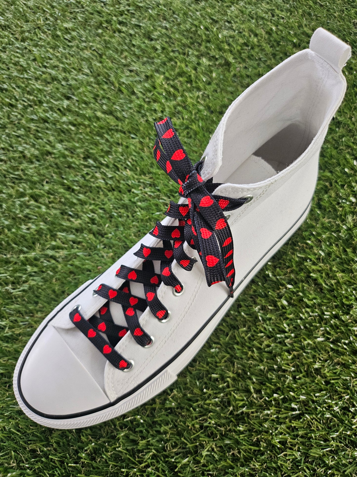White converse boot with black and red shoelaces
