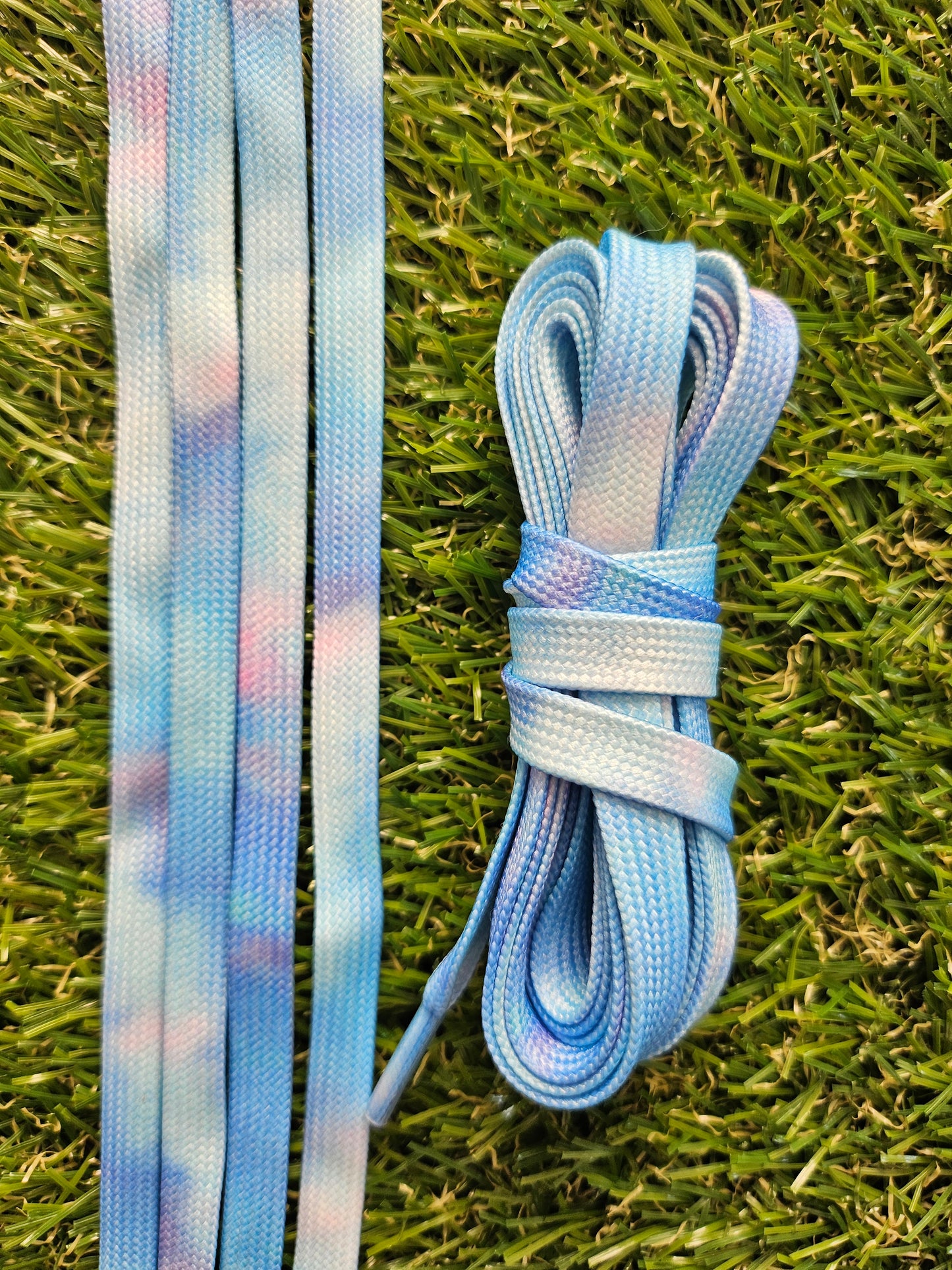 Soft blue and lilac fusion shoelaces laid on grass