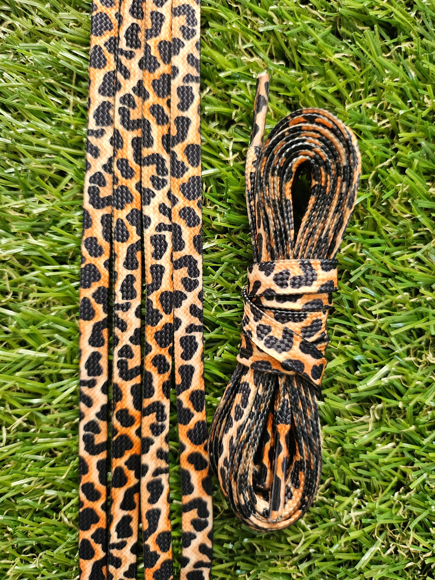 Leopard print shoelaces on a grass background