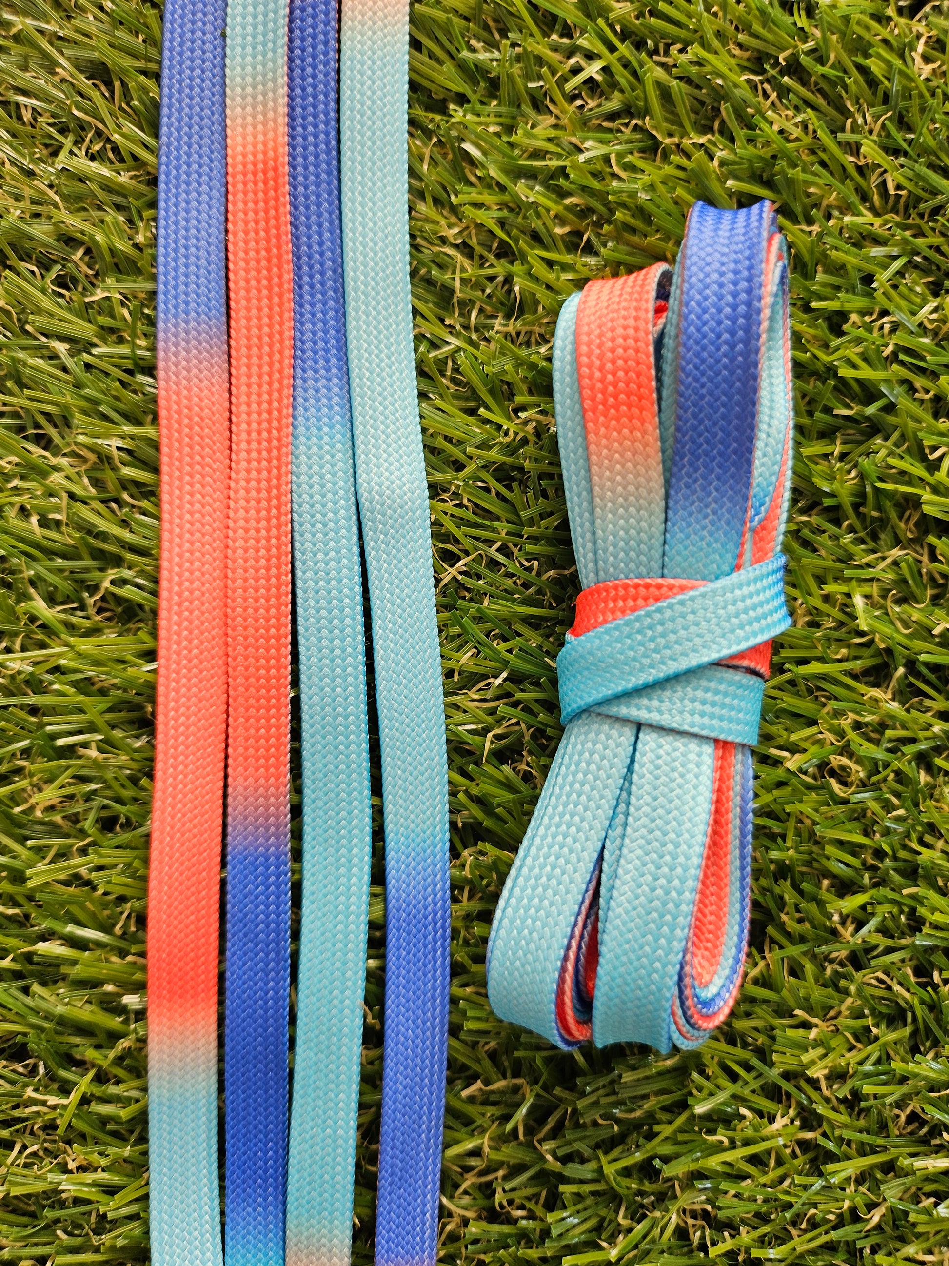 The colours of a bright ocean sunset coloured shoelaces on grass