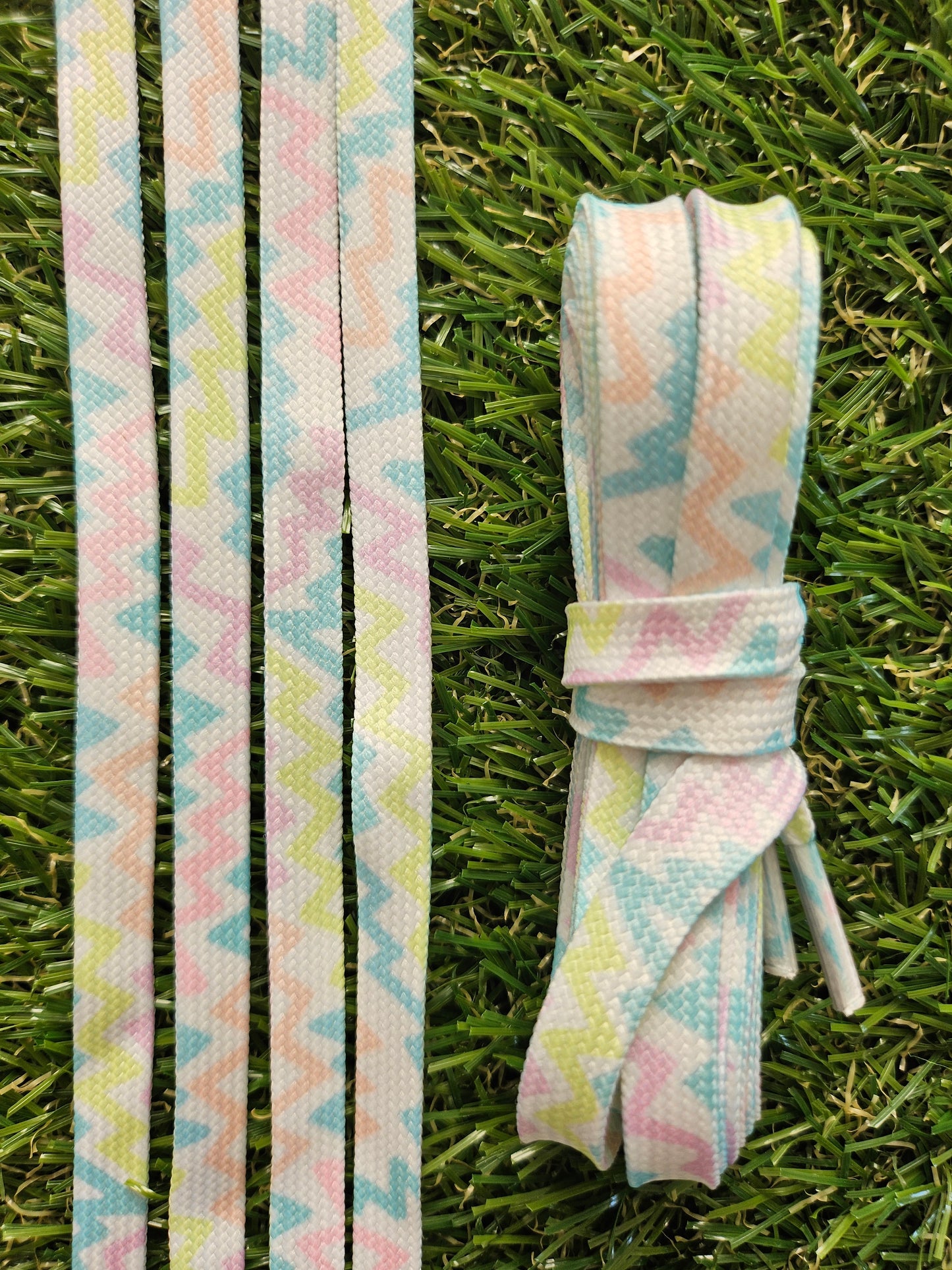 Pastel zigzag patterned shoelaces laid flat and styled in a white trainer