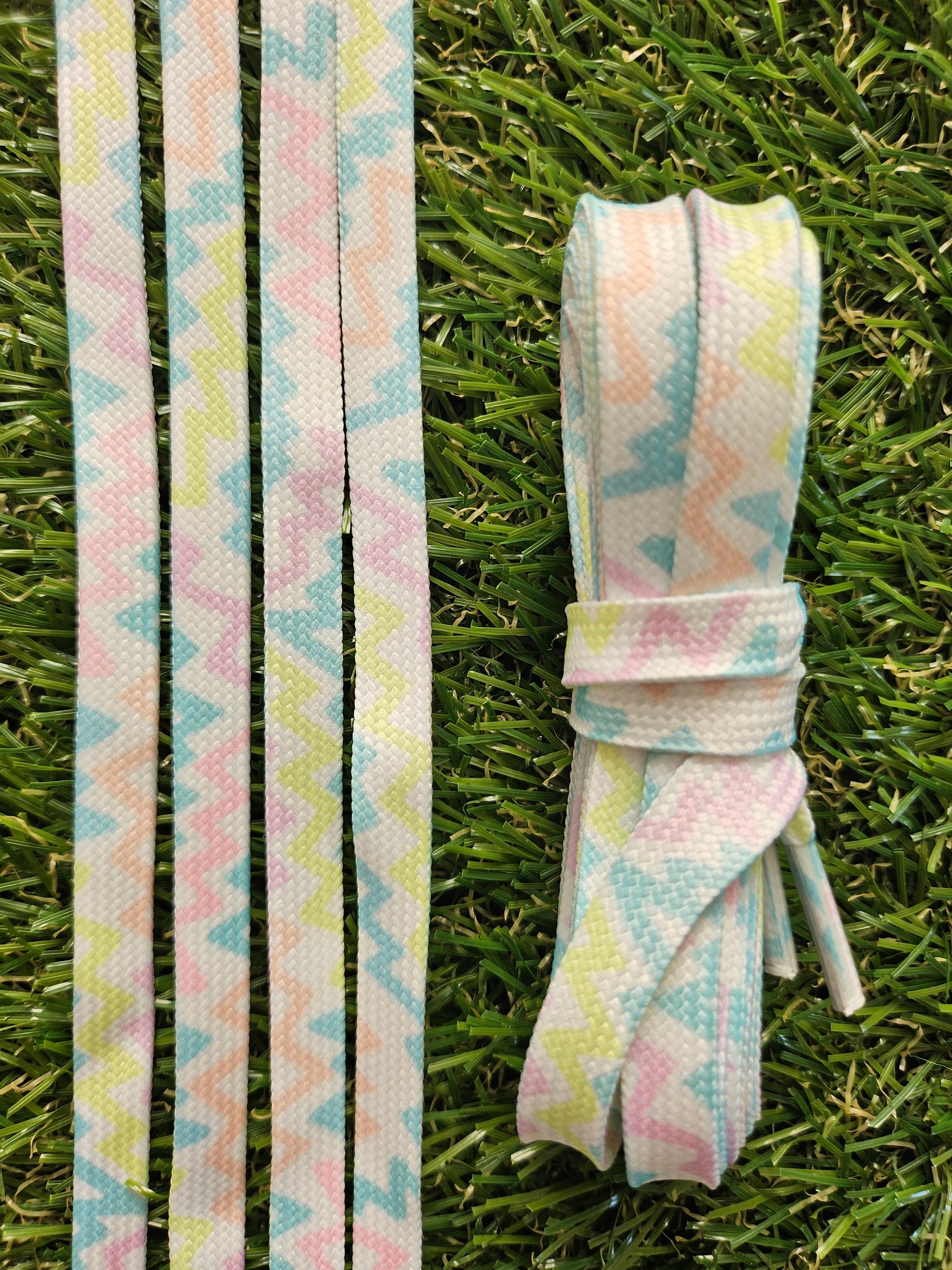Pastel zigzag patterned shoelaces laid flat and styled in a white trainer